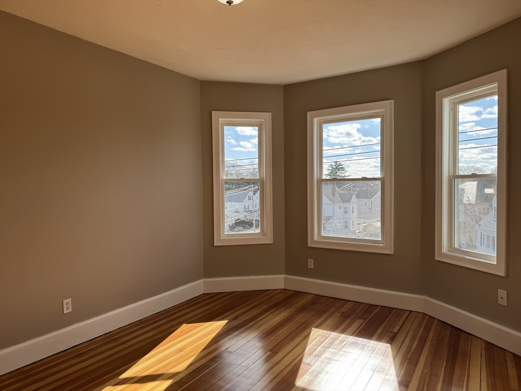 630 Metropolitan Avenue, Unit 3 Boston, MA 02136 - Photo 25 of 31 a view of an empty room with wooden floor and a window