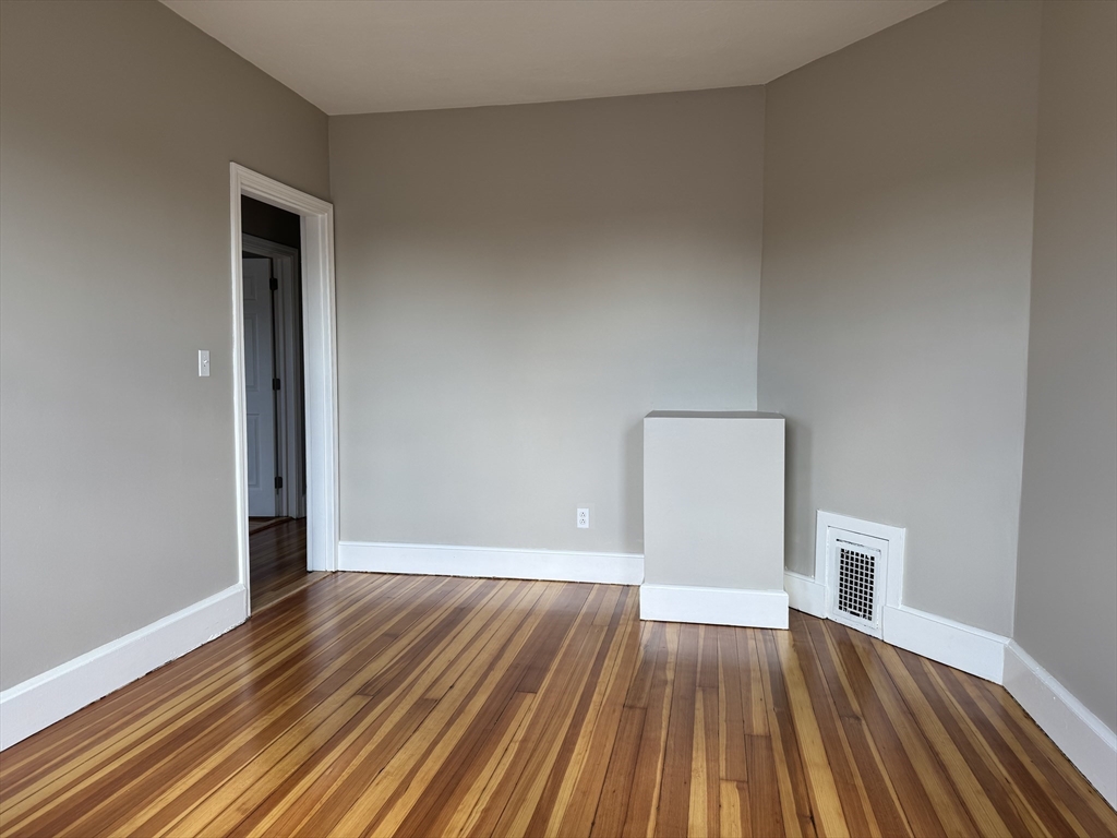 630 Metropolitan Avenue, Unit 3 Boston, MA 02136 - Photo 27 of 31 a view of an empty room with wooden floor
