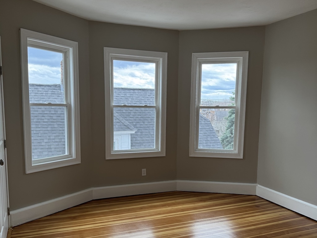 630 Metropolitan Avenue, Unit 3 Boston, MA 02136 - Photo 28 of 31 a view of an empty room with wooden floor and a window