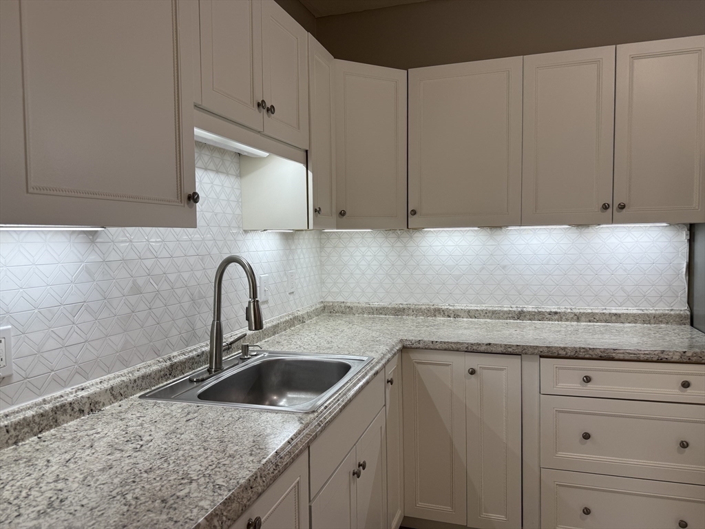630 Metropolitan Avenue, Unit 3 Boston, MA 02136 - Photo 3 of 31 a kitchen with granite countertop a sink and cabinets