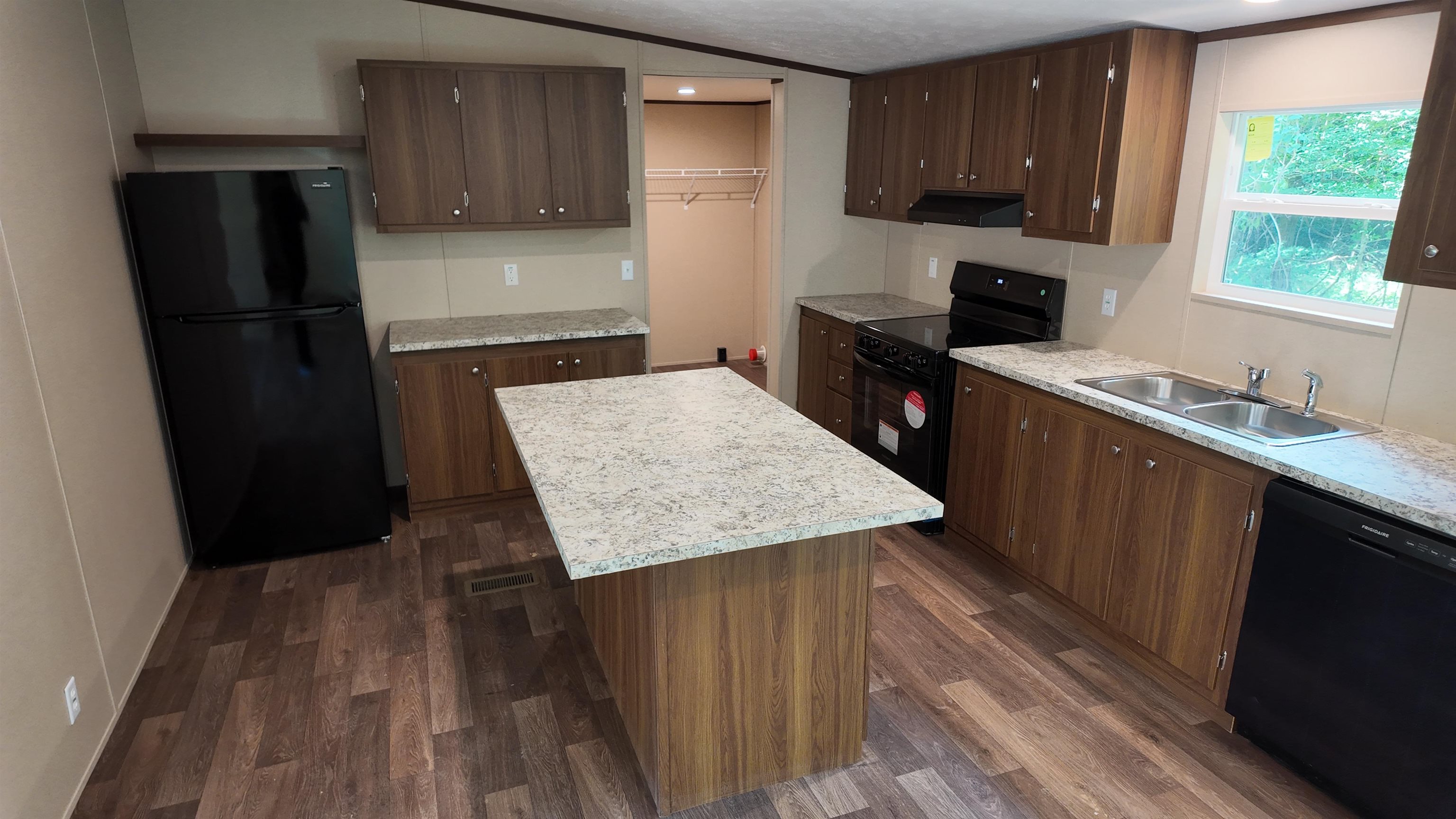 208 Marcy Cove Ripley, TN 38063 - Photo 3 of 14 Kitchen with black appliances, light countertops, dark wood-type flooring, a center island, and exhaust hood