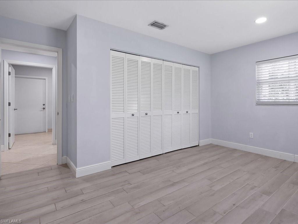 4220 11th Avenue Southwest Naples, FL 34116 - Photo 13 of 25 a view of an empty room with wooden floor