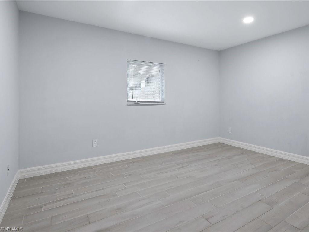 4220 11th Avenue Southwest Naples, FL 34116 - Photo 14 of 25 a view of an empty room with wooden floor and a window