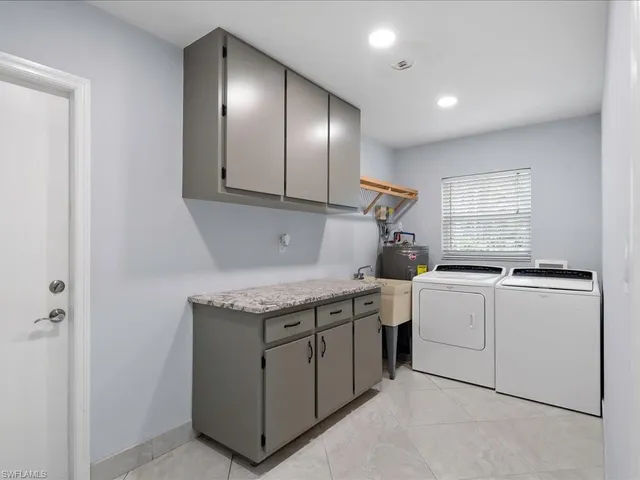 a kitchen with a sink a stove cabinets and stainless steel appliances