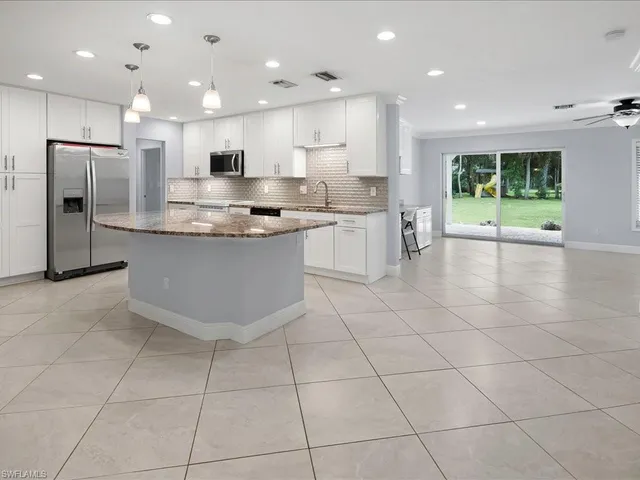 a large kitchen with stainless steel appliances lots of counter space and a window