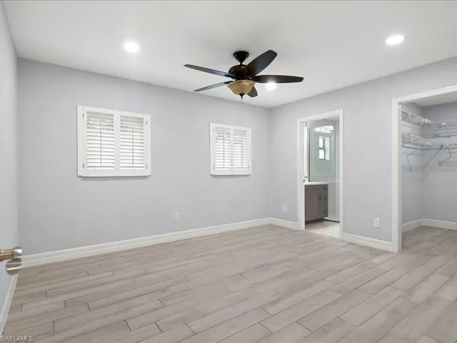 a view of an empty room with a window and a ceiling fan