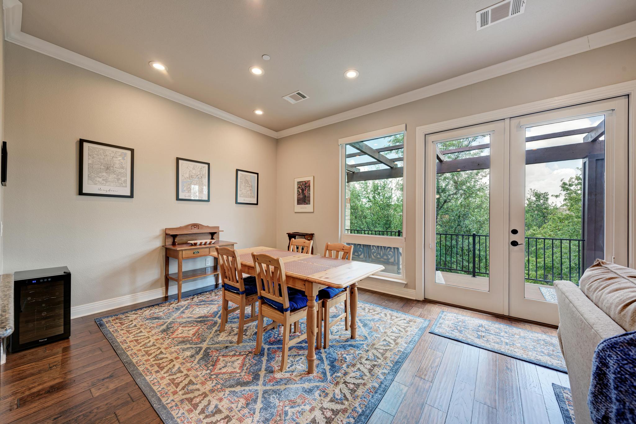 2601 North Quinlan Park Road, Unit 506 Austin, TX 78732 - Photo 20 of 39 Hardwood floors complement this dining area, featuring a wall of windows and French doors opening to outdoor living.
