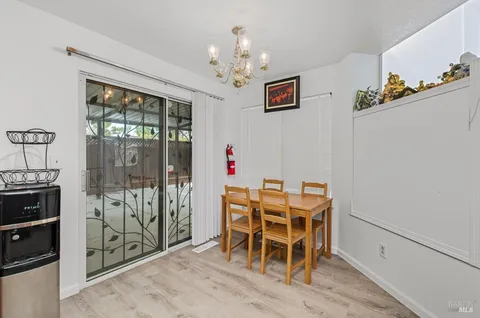 a view of a dining room with furniture a chandelier and wooden floor