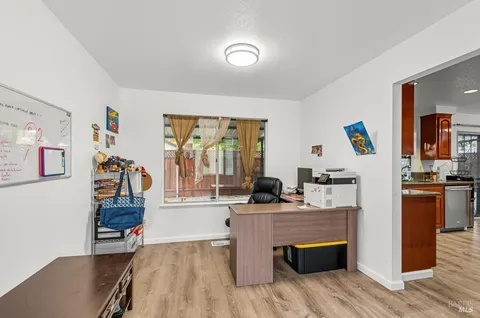 a living room with stainless steel appliances kitchen island granite countertop a stove and a refrigerator