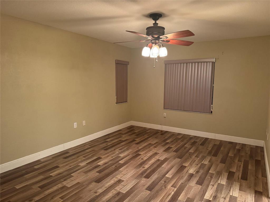 6351 Landings Way Tamarac, FL 33321 - Photo 14 of 16 a view of an empty room with wooden floor and a chandelier fan