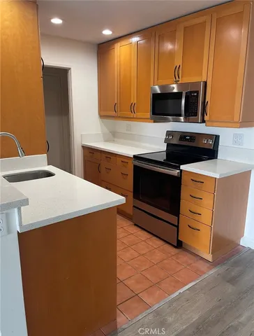 a kitchen with stainless steel appliances a stove a microwave and white cabinets