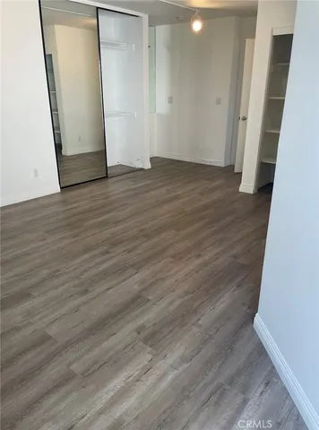 an empty room with wooden floor and mirror