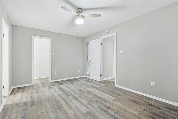 a view of an empty room with wooden floor
