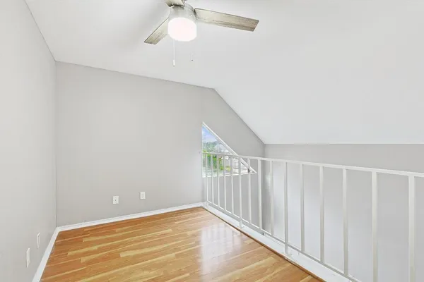 a view of a room with wooden floor and fan