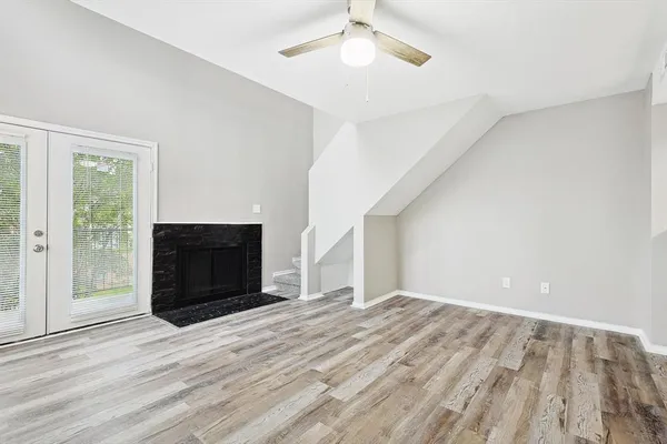 a view of empty room with wooden floor and fireplace