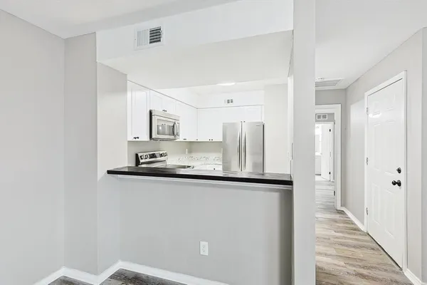 a kitchen with stainless steel appliances granite countertop a sink and a refrigerator