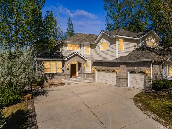 a view of a house with a yard and large tree