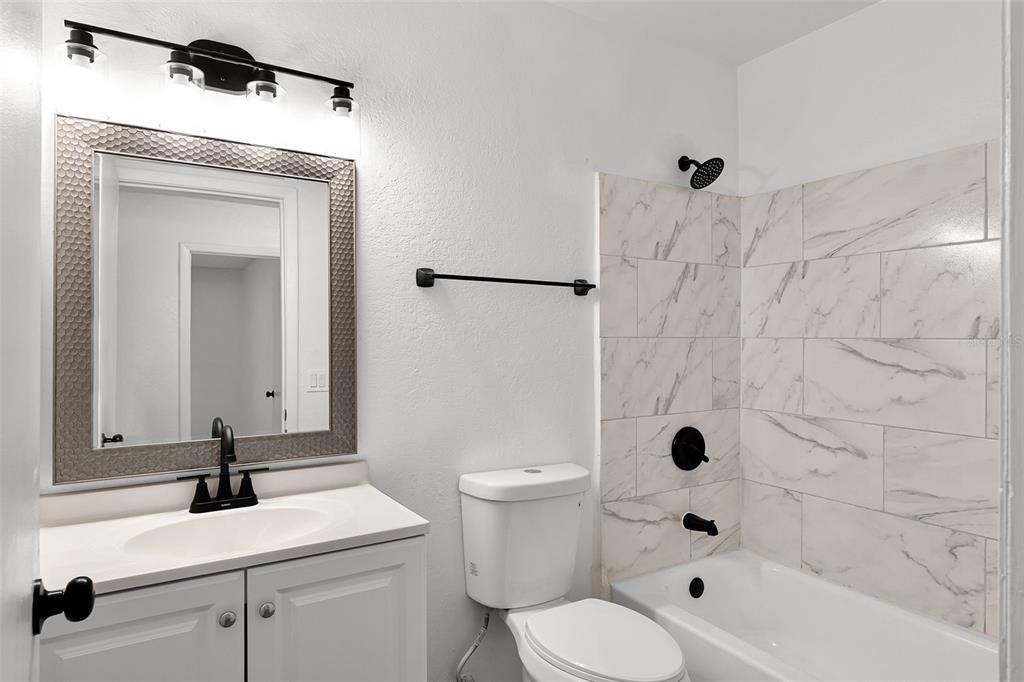 2722 Graduate Court Orlando, FL 32826 - Photo 21 of 33 a bathroom with a sink toilet a mirror and shower