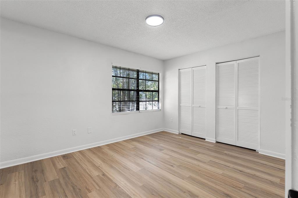 2722 Graduate Court Orlando, FL 32826 - Photo 22 of 33 an empty room with wooden floor and windows