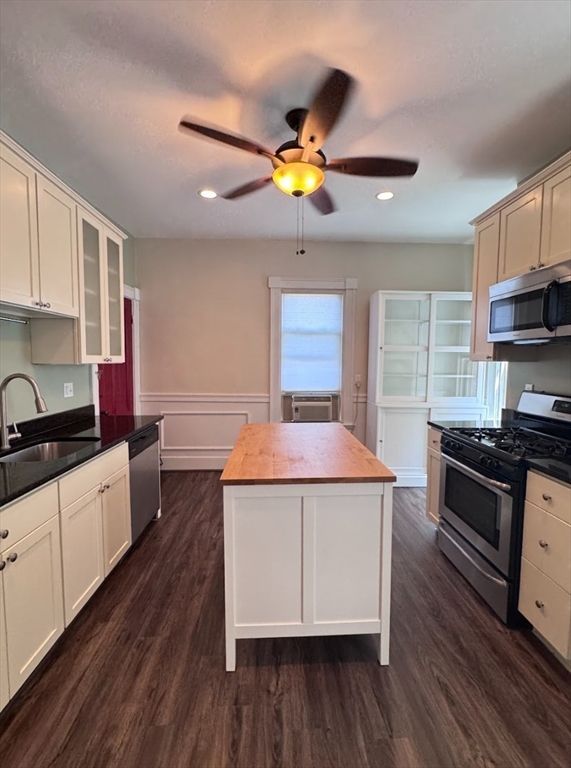 a kitchen with a stove a sink a refrigerator cabinets and wooden floor