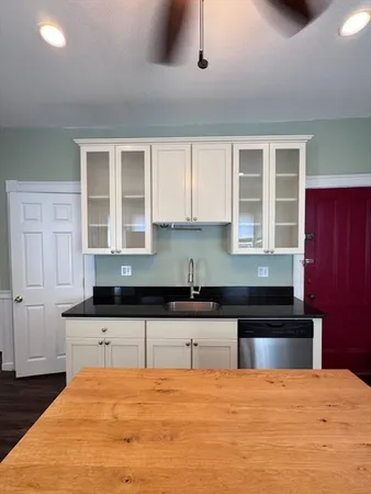 a kitchen with granite countertop a sink and cabinets