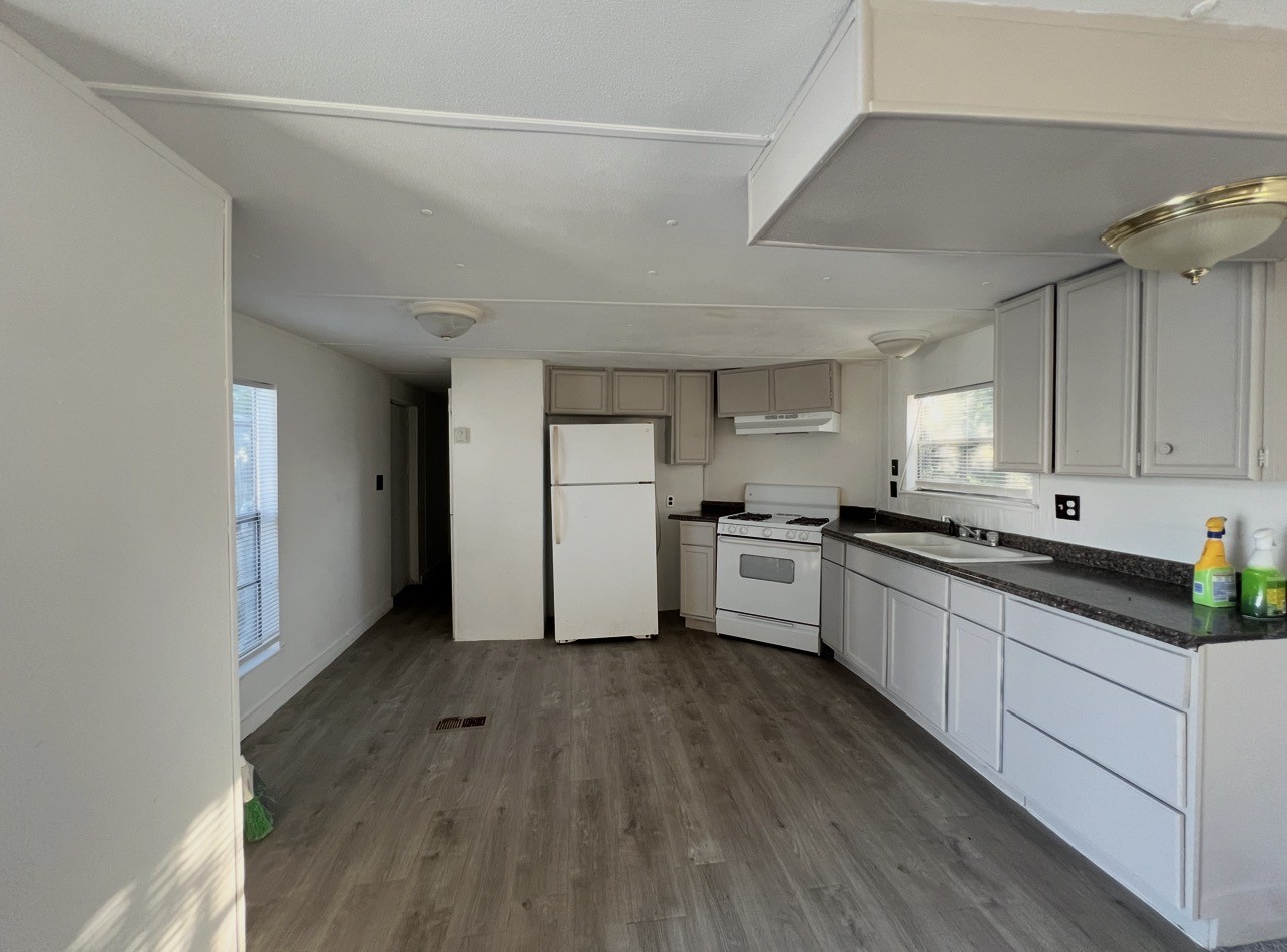 1511-1 Jones Street, Unit 1 Rosenberg, TX 77471 - Photo 3 of 13 a kitchen with granite countertop white cabinets and white appliances