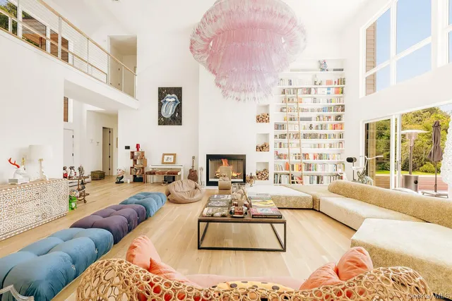 a living room with fireplace furniture and a large window
