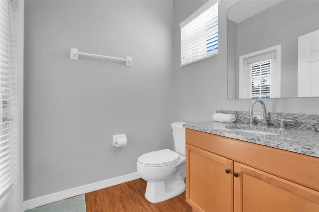 a bedroom with a bed table flowerpot and window