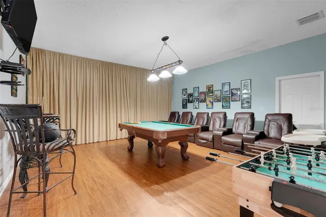 a living room with furniture a flat screen tv and a dining table