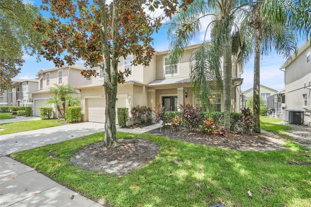 a view of a house with a yard and palm trees