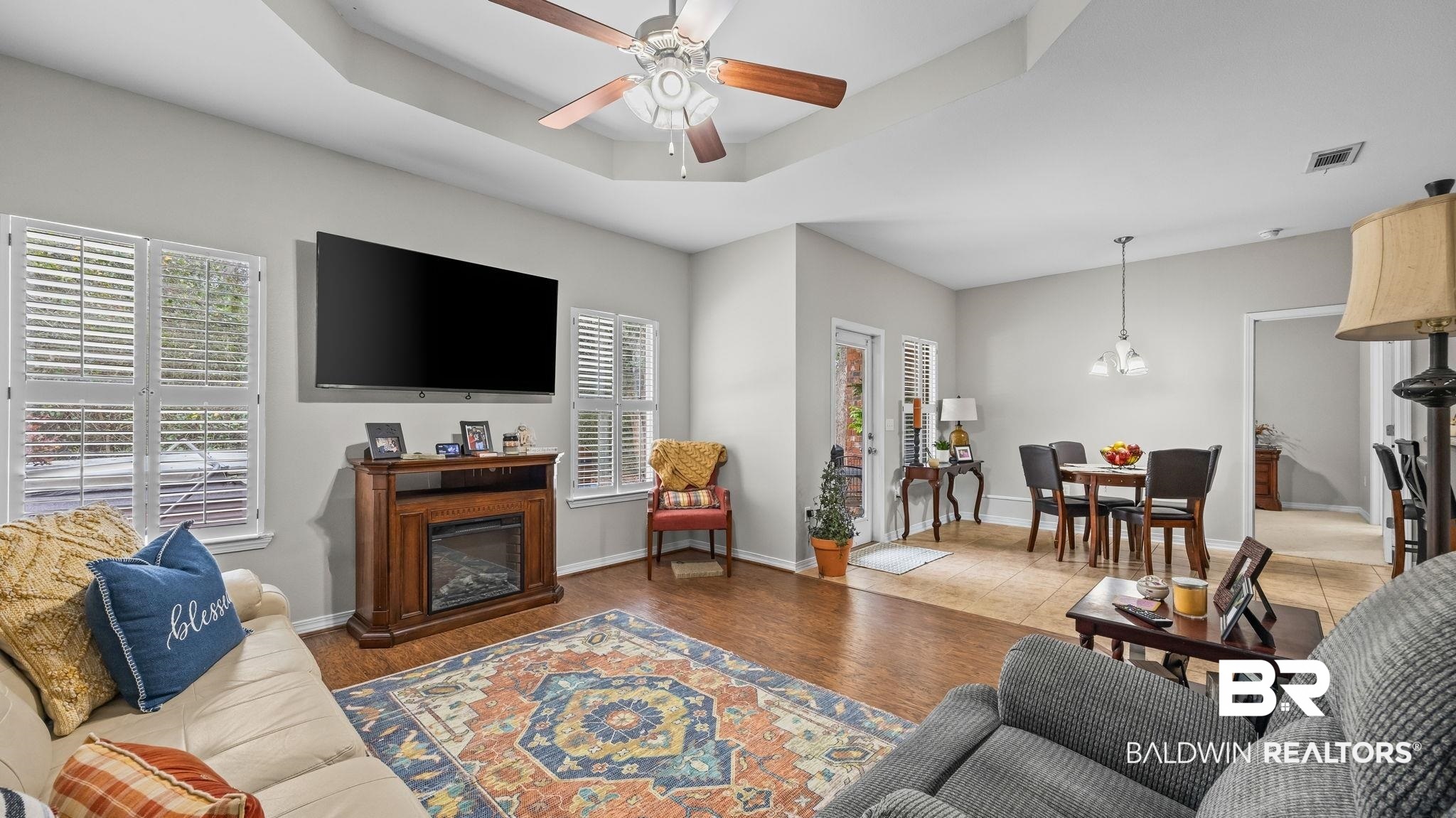 1090 Melbourne Court Foley, AL 36535 - Photo 28 of 38 Living area with healthy amount of natural light, wood finished floors, ceiling fan, a glass covered fireplace, and a tray ceiling
