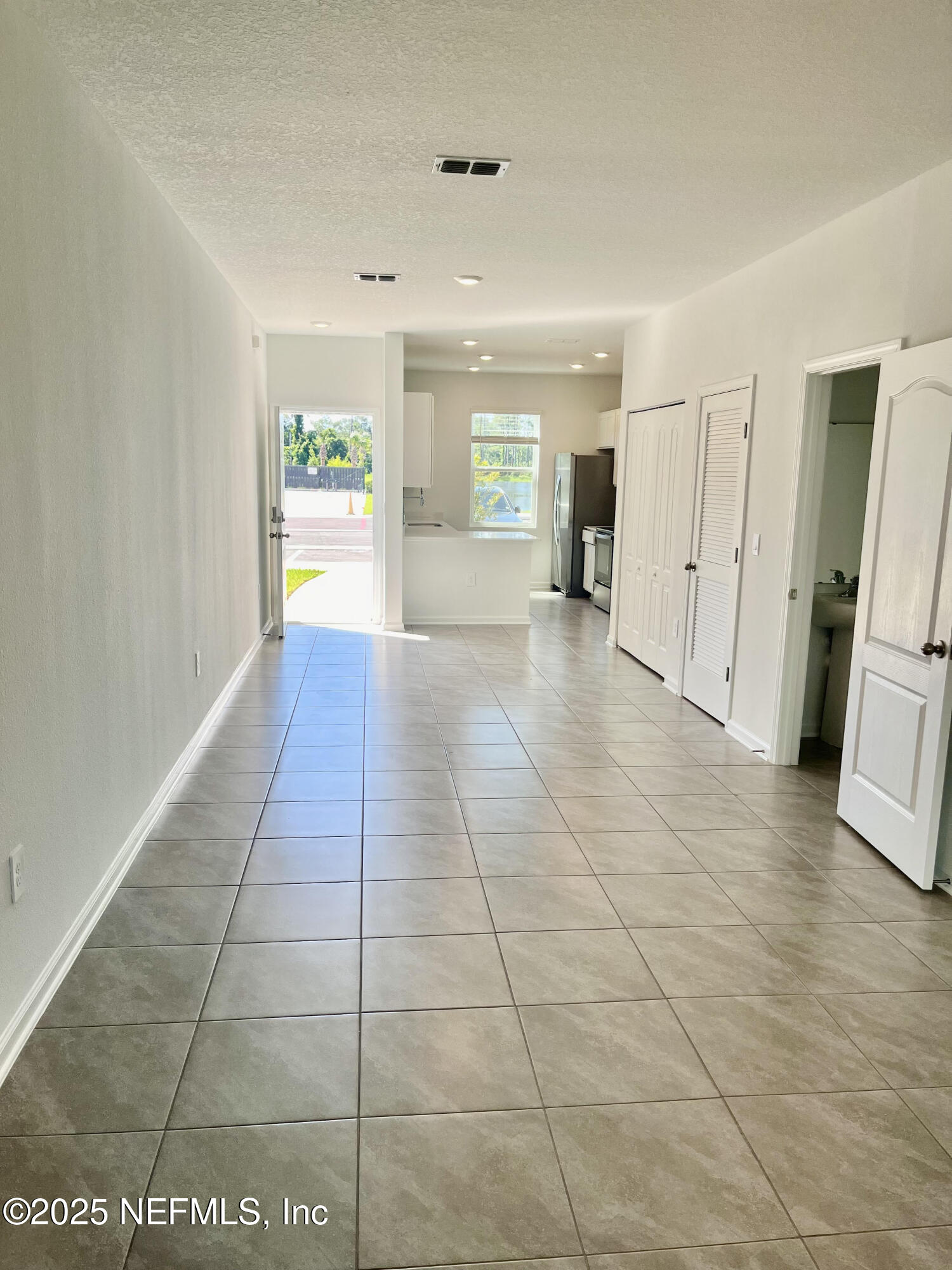 73 Hidden Mdws Road St. Augustine, FL 32095 - Photo 4 of 25 a view of a hallway with wooden floor and a living room