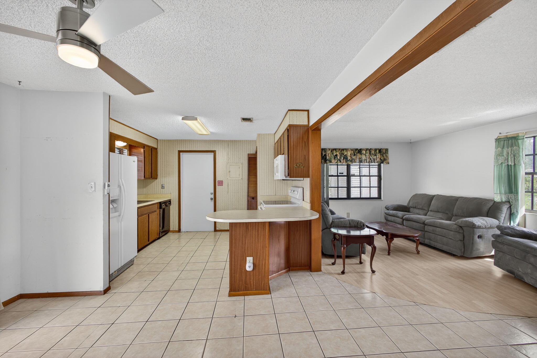 1332 West 33rd Street Riviera Beach, FL 33404 - Photo 9 of 25 a living room with furniture a dining table and chairs with kitchen view
