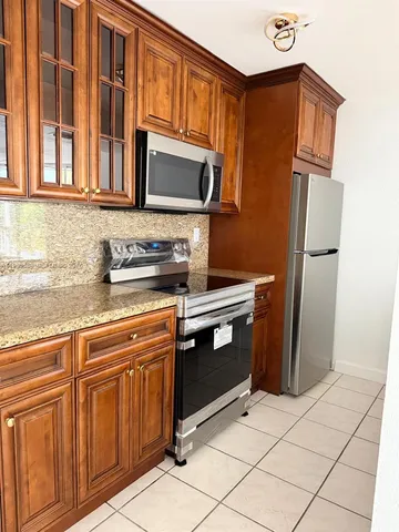 a kitchen with stainless steel appliances granite countertop a refrigerator stove and sink