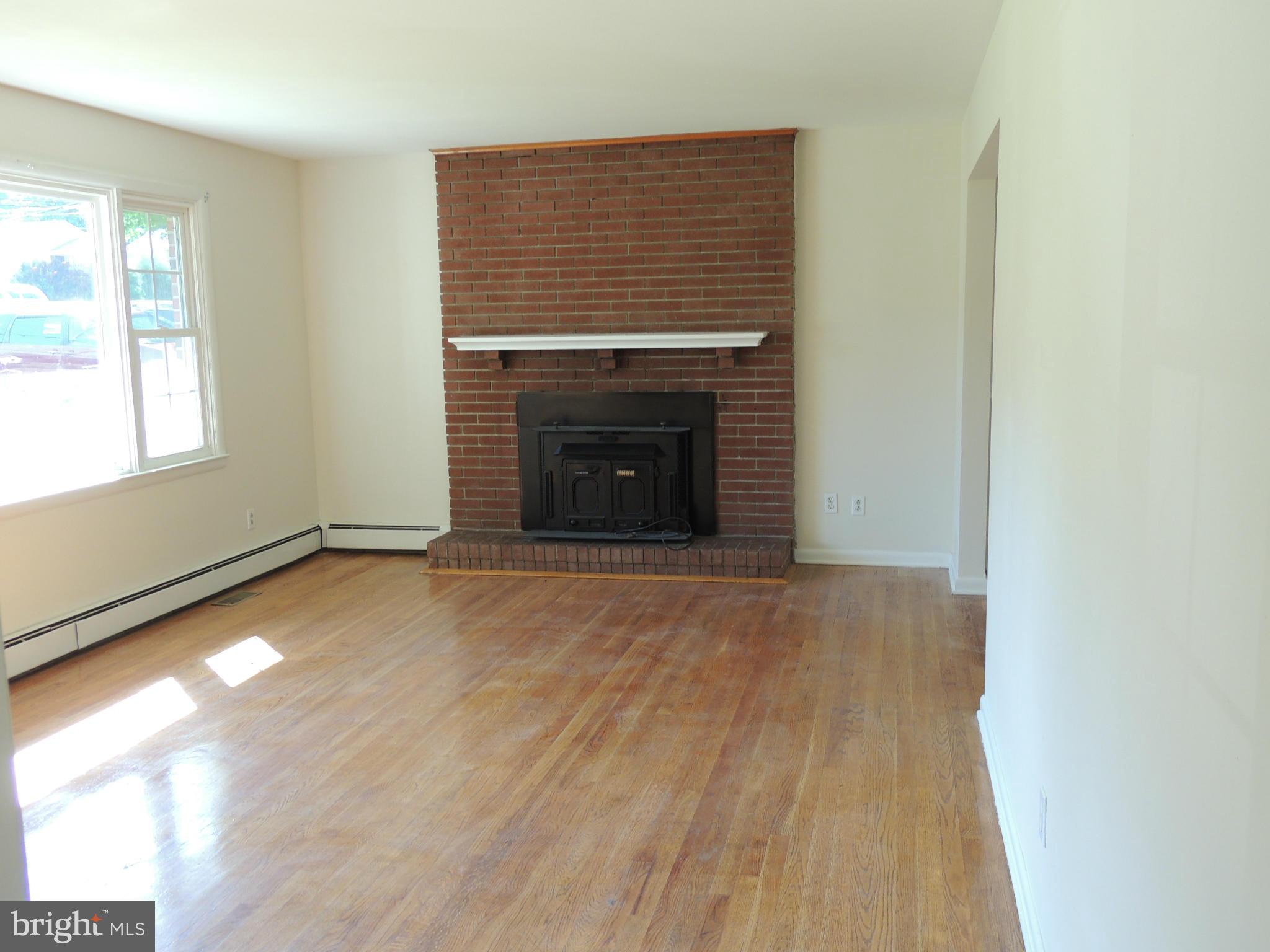 1321 Spring Avenue Baltimore, MD 21237 - Photo 3 of 27 an empty room with windows and fireplace