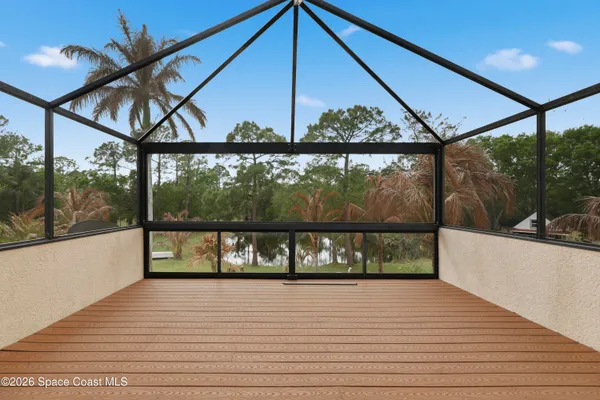 a backyard of a house with table and chairs plants and large tree