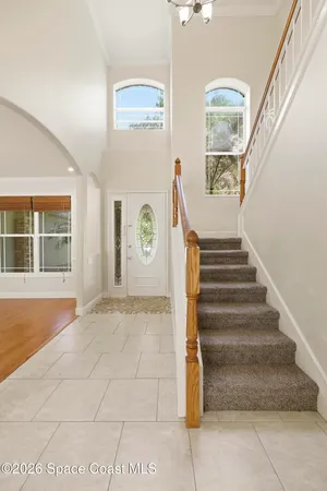 a view of an empty room with wooden floor and a fireplace