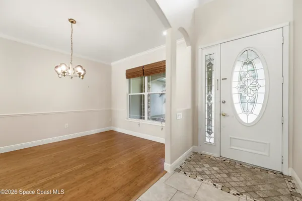 a view of an empty room with wooden floor and a fireplace