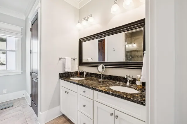 a bathroom with a granite countertop sink a mirror and shower