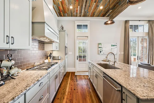 a view of a dining room with furniture one side kitchen view and wooden floor