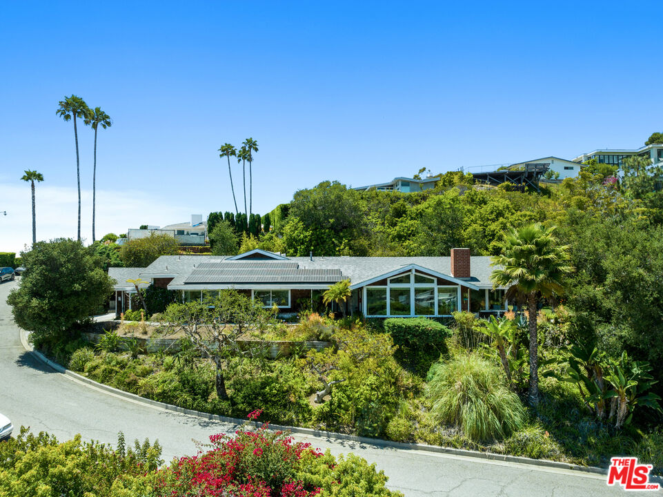a view of a house with a yard and potted plants
