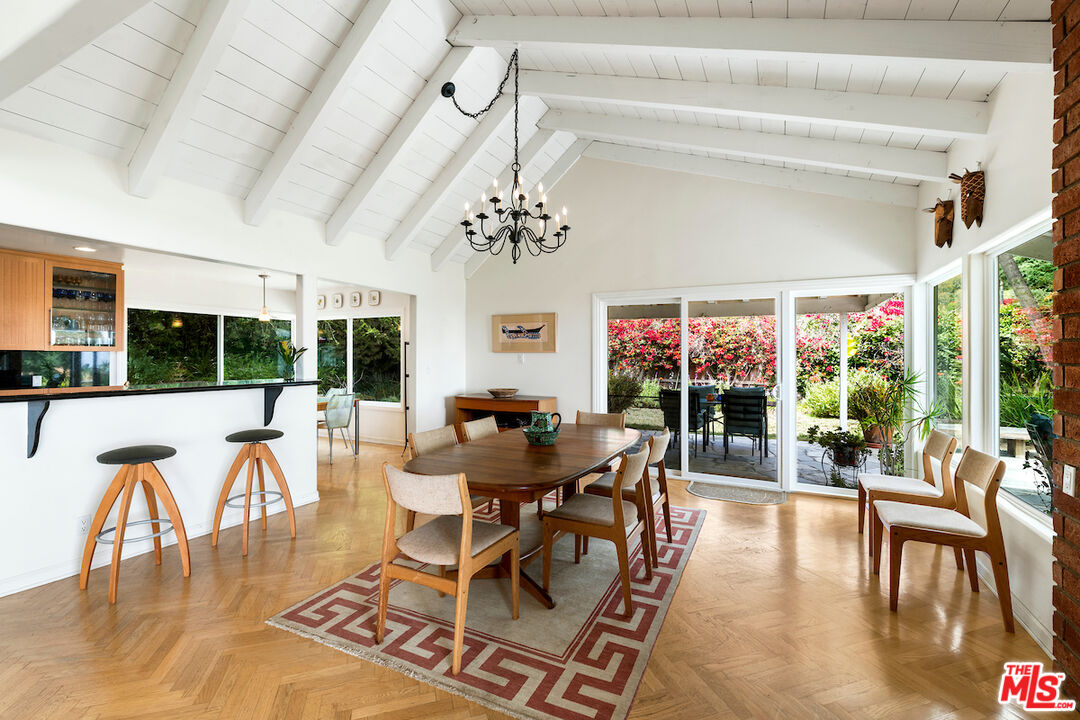 1336 Las Canoas Road Pacific Palisades, CA 90272 - Photo 12 of 37 a view of a dining room with furniture wooden floor and chandelier