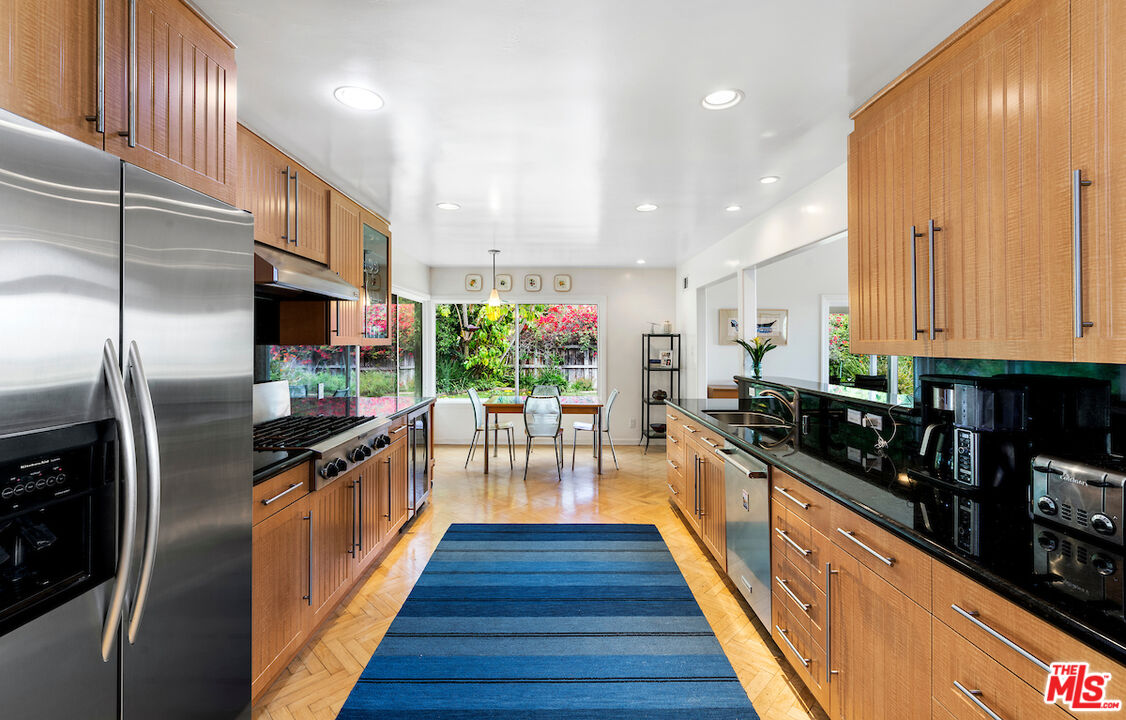 1336 Las Canoas Road Pacific Palisades, CA 90272 - Photo 13 of 37 a kitchen with stainless steel appliances a sink stove and refrigerator