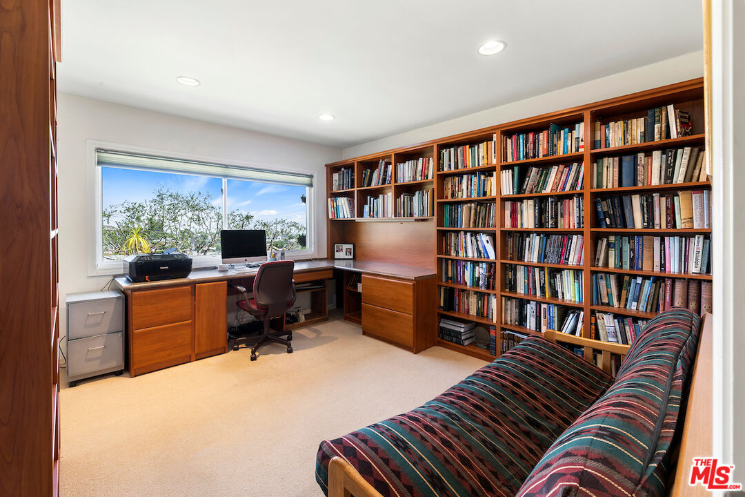 1336 Las Canoas Road Pacific Palisades, CA 90272 - Photo 20 of 37 a bedroom with furniture and a book shelf
