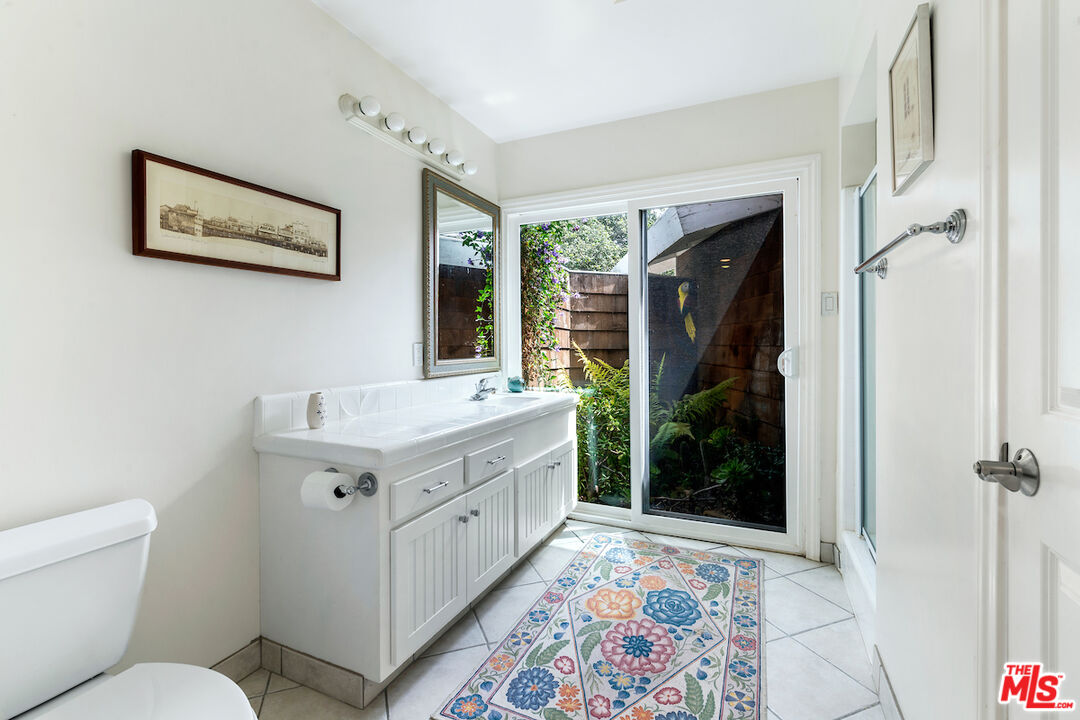 1336 Las Canoas Road Pacific Palisades, CA 90272 - Photo 22 of 37 a bathroom with a granite countertop sink mirror vanity and toilet
