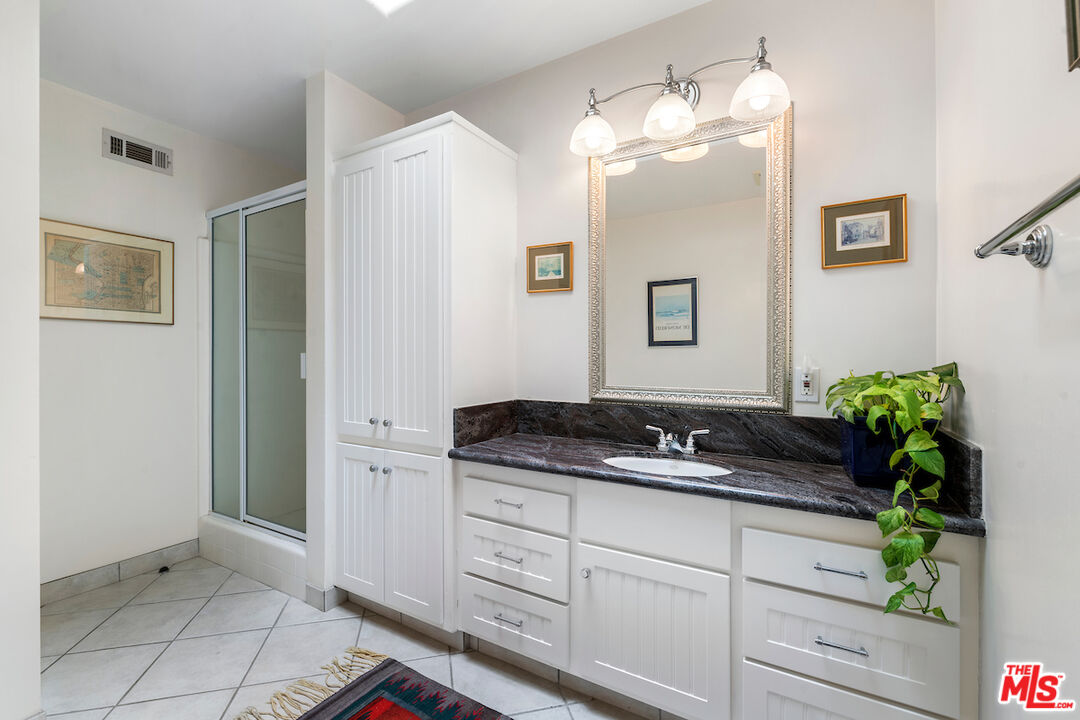 1336 Las Canoas Road Pacific Palisades, CA 90272 - Photo 24 of 37 a bathroom with a granite countertop sink a mirror and a potted plant