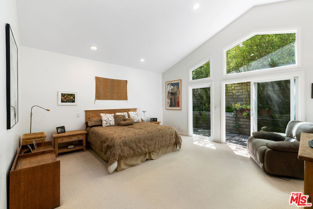 1336 Las Canoas Road Pacific Palisades, CA 90272 - Photo 25 of 37 a bedroom with a bed and glass window