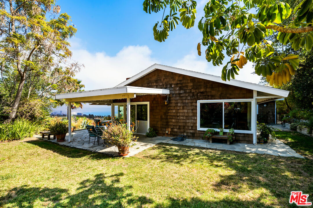 1336 Las Canoas Road Pacific Palisades, CA 90272 - Photo 30 of 37 a front view of a house with a yard table and chairs