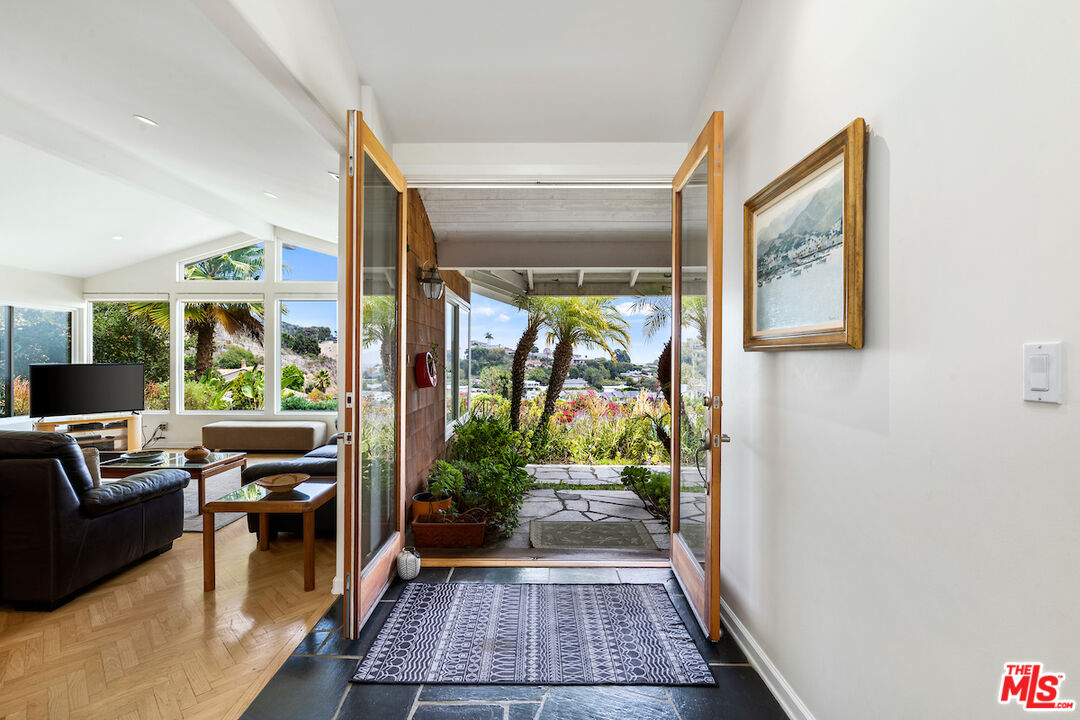 1336 Las Canoas Road Pacific Palisades, CA 90272 - Photo 6 of 37 a living room with furniture and a floor to ceiling window