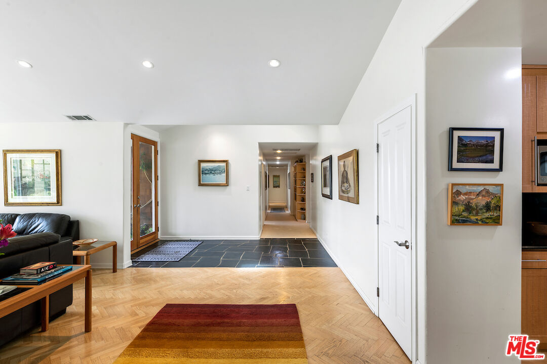 1336 Las Canoas Road Pacific Palisades, CA 90272 - Photo 7 of 37 a view of a hallway with wooden floor and furniture